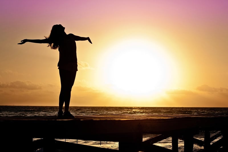 Woman practicing self-love through yoga at sunset